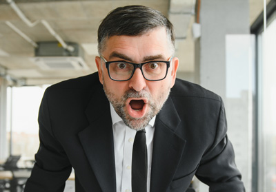 An angry attorney leaning over the desk yelling.
