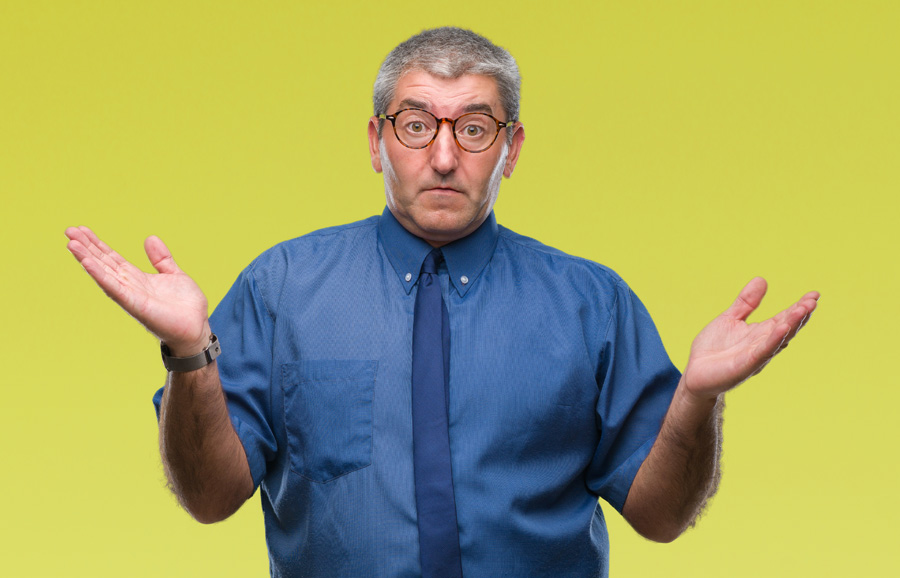 Confused man with glasses shrugging.
